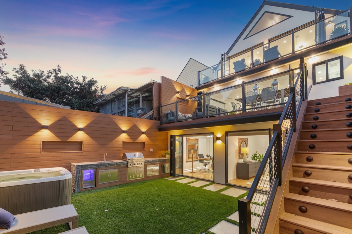 Modern custom home at dusk with tiered deck